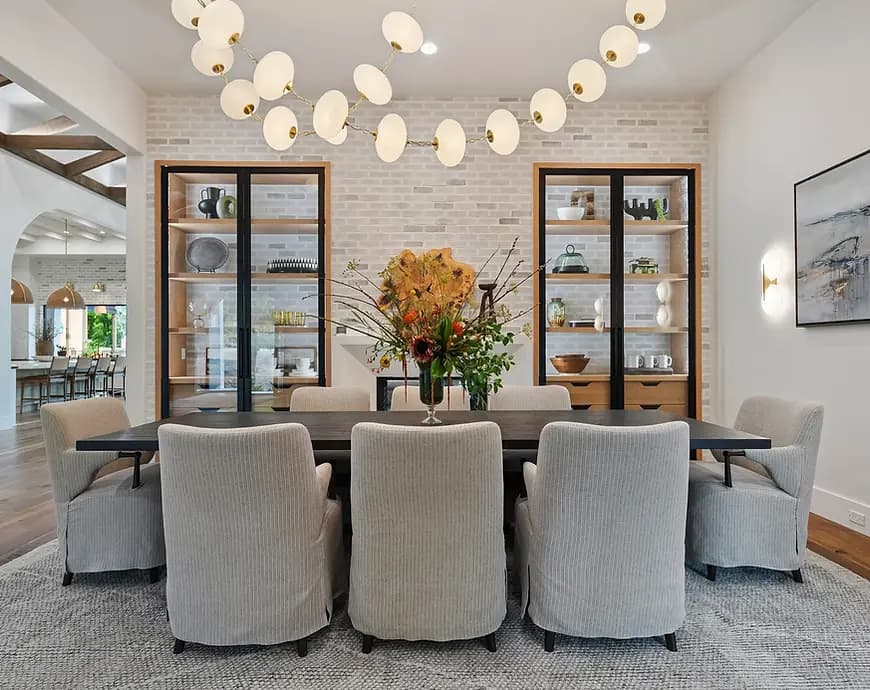 Alla Famiglia Street of Dreams luxury dining room designed by Greylyn Wayne — modern chandelier, upholstered chairs, built-in cabinetry